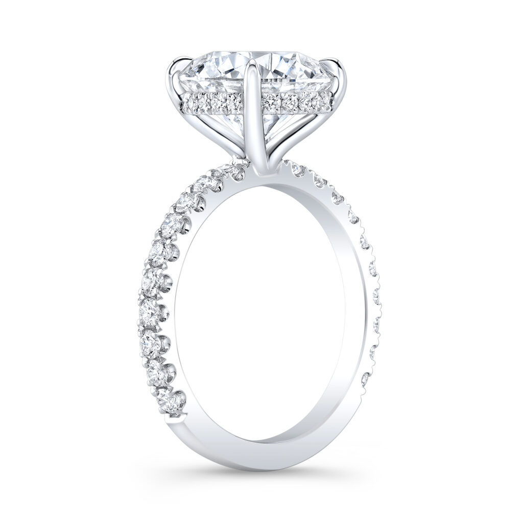 A delicate 4-prong under halo cradles the sparkling diamond, encircling it with smaller pavé diamonds.